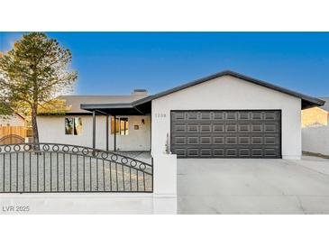 Remodeled single story home with modern gray garage door and new landscaping at 1208 Marion Dr, Las Vegas, NV 89110