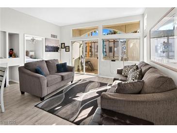 Bright living room with two sofas, large windows, and access to a patio at 3125 N Buffalo Dr # 2120, Las Vegas, NV 89128