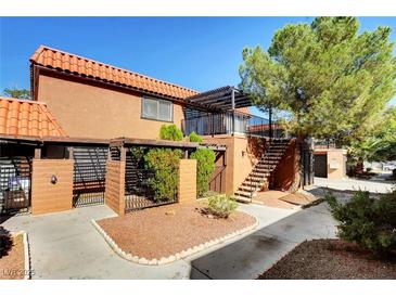 Spanish style building exterior with walkway, stairs and landscaping at 330 Shadybrook Ln # D, Las Vegas, NV 89107