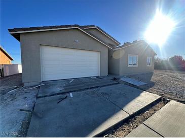 Newly constructed single-story home with a two-car garage and neutral exterior finish at 3414 Mount Charleston Dr, Pahrump, NV 89048