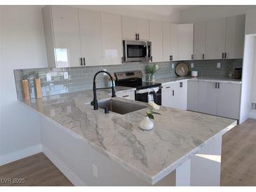 Modern kitchen with sleek cabinetry, quartz countertops, and stainless steel appliances at 3414 Mount Charleston Dr, Pahrump, NV 89048