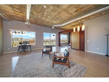 Open living area with city views, modern furniture, and polished concrete floors at 900 Las Vegas Blvd # 901, Las Vegas, NV 89101