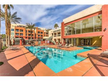 Beautiful community pool with lounge chairs surrounded by lovely landscaping, perfect for relaxation at 43 E Agate Ave # 403, Las Vegas, NV 89123