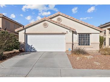 Single-story house with a white garage door and landscaping at 8991 Union Gap Rd, Las Vegas, NV 89123