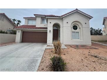 Two-story house with brown garage door and desert landscaping at 2104 Fountain View Dr, Las Vegas, NV 89134