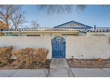 Front view of a single-story house with a blue gate and stucco wall at 2137 Willowbury Dr # B, Las Vegas, NV 89108