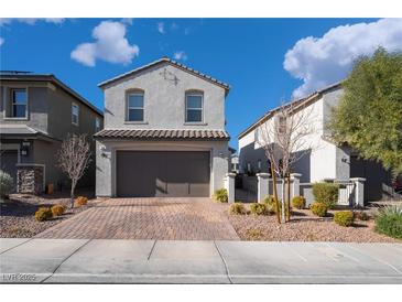 Two-story house with gray exterior, brown garage door, and landscaped front yard at 406 Misterioso St, Henderson, NV 89011