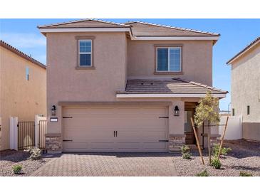 Two-story house with tan siding, two-car garage, and landscaped front yard at 6270 Blood Lily Ave, Las Vegas, NV 89122