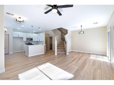 Bright living room with fireplace and wood-look floors at 6529 Za Zu Pitts Ave # 102, Las Vegas, NV 89122