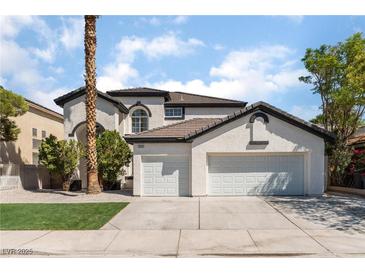 Two-story house with three-car garage, landscaping, and palm tree at 6808 Rose Petal Ave, Las Vegas, NV 89130