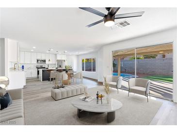 Open living room showcasing a kitchen, pool view, and modern furniture at 9541 Summersweet Ct, Las Vegas, NV 89123