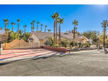 Single-story house with palm trees and a large driveway at 7755 Coley Ave, Las Vegas, NV 89117