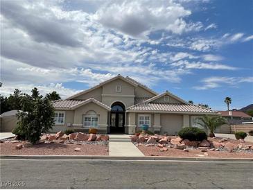 Single-story home with attractive landscaping and a large driveway at 121 E Cypress Dr, Henderson, NV 89015