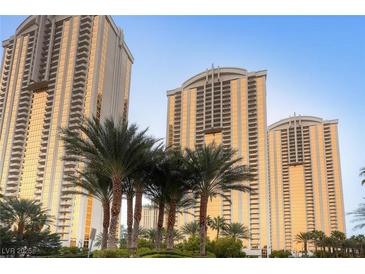 Luxury high-rise building with modern architecture and palm trees at 135 E Harmon Ave # 1007, Las Vegas, NV 89109