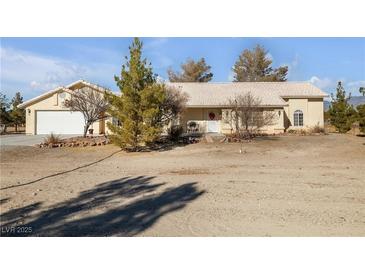 Single-story house with attached garage and desert landscaping at 1230 Bruce St, Pahrump, NV 89048