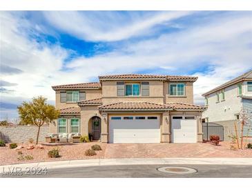 Two-story house with three-car garage, landscaping, and brick driveway at 1556 Bryce Canyon St, Boulder City, NV 89005