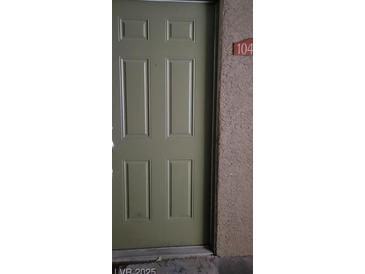 Well-maintained light green front door with number 104 at 2101 Blue Breeze Dr # 104, Las Vegas, NV 89128