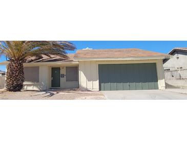 House exterior featuring a single-story home with a two-car garage and a palm tree at 2102 E Russell Rd, Las Vegas, NV 89119