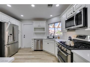 Modern kitchen features stainless steel appliances and white cabinetry at 2856 Billy Casper Dr, Las Vegas, NV 89134