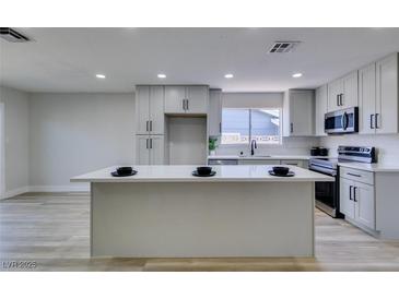 Modern kitchen with island, stainless steel appliances, and white cabinets at 3994 Avonwood Ave, Las Vegas, NV 89121