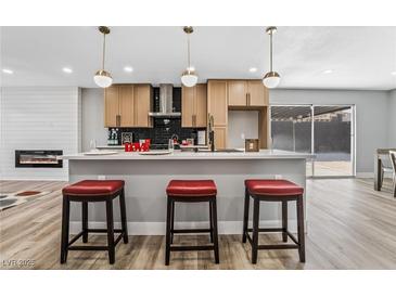 Modern kitchen with island, stainless steel appliances, and light wood cabinets at 4431 El Cebra Way, Las Vegas, NV 89121