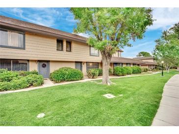 Tan two-story townhome with landscaping and walkway at 6133 Meadowgrass Ln, Las Vegas, NV 89103