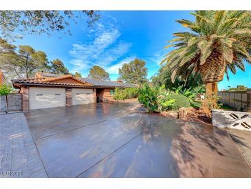 Ranch style home with two car garage, mature landscaping, and large driveway at 6640 Palmyra Ave, Las Vegas, NV 89146