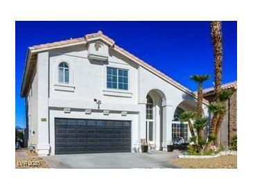 Two-story house with a black garage door and landscaping at 8896 Dove Cove Dr, Las Vegas, NV 89129