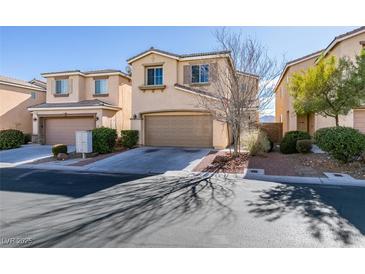 Two-story house with tan siding, attached garage, and landscaping at 9279 Cabin Cove Ave, Las Vegas, NV 89148