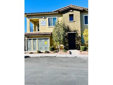 Tan two-story townhome with a private balcony and attached garage at 965 Nevada State Dr # 1202, Henderson, NV 89002