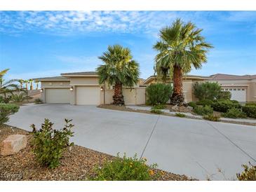 Tan two-story house with two palm trees and a long driveway at 10275 Tresor Ct, Las Vegas, NV 89135