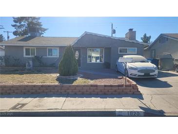 Ranch style home with gray exterior, landscaping, and a brick retaining wall at 1920 Wendell Ave, Las Vegas, NV 89101