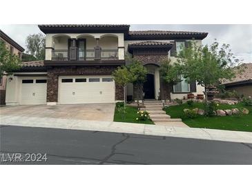 Two-story home with stone accents, three-car garage, and landscaped yard at 2768 Liberation Dr, Henderson, NV 89044