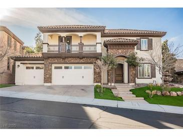 Two-story house with stone accents, three-car garage, and balcony at 2768 Liberation Dr, Henderson, NV 89044