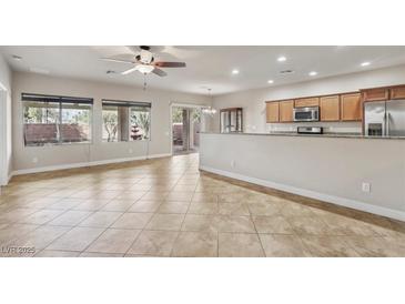 Open-concept living room features tile flooring, many windows, and seamless flow into the kitchen at 3363 Blue Ribbon Downs St, Las Vegas, NV 89122