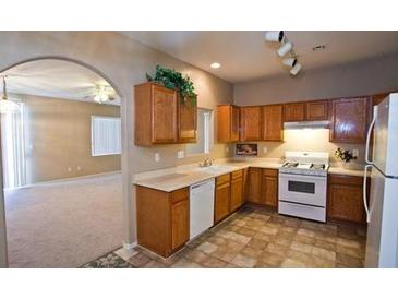 Bright kitchen features wood cabinets, white appliances, and tile flooring at 5066 El Castano Ave, Las Vegas, NV 89108