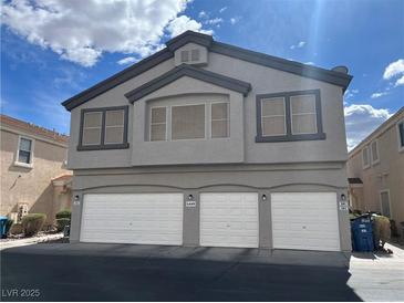 Three car garage exterior of home with gray paint and a window on the second story at 6449 Stone Dry Ave # 101, Henderson, NV 89011