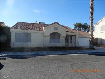 Single-story house with tile roof, screened windows, and a two-car garage at 6617 Old Newbury Ave, Las Vegas, NV 89108