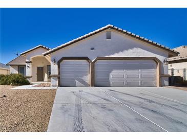 Two-story house with a two-car garage and desert landscaping at 5020 Valero Ct, Pahrump, NV 89060