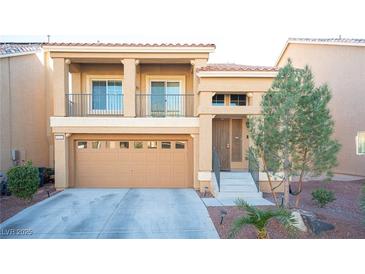 Two-story house with tan exterior, two-car garage, and balcony at 5391 Kennedy Hill Ave, Las Vegas, NV 89139