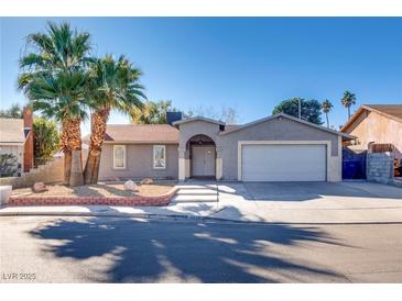 Single-story house with a two-car garage and landscaped front yard at 6725 Carrera Dr, Las Vegas, NV 89103