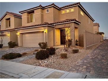 Two-story house with attached garage, landscaping, and a brick driveway at 8976 Sweet Chestnut Ln, Las Vegas, NV 89178