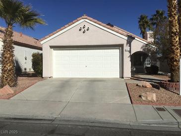 Single-story house with white garage door and desert landscaping at 9612 World Cup Dr, Las Vegas, NV 89117