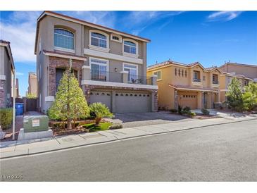 Two-story house with a three-car garage and landscaped front yard at 10166 Bishops Peak Ct, Las Vegas, NV 89141