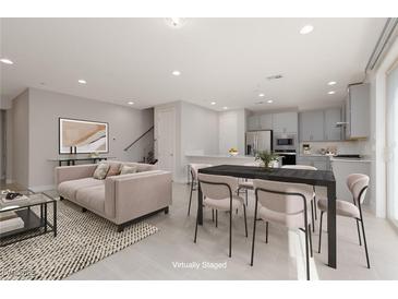 Open concept kitchen and dining area with modern gray cabinets and stainless steel appliances at 11327 Gravitation Dr, Las Vegas, NV 89135