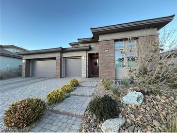 Modern two-story home with a three-car garage and landscaped front yard at 12422 Tudor Arch Dr, Las Vegas, NV 89138