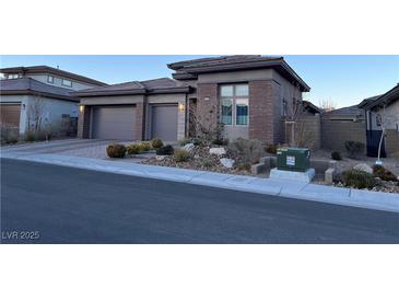 Single-story home with a three-car garage and landscaped front yard at 12422 Tudor Arch Dr, Las Vegas, NV 89138