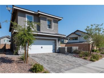 Two-story house with gray exterior, white garage door, and landscaped front yard at 126 Ostinato Ln, Henderson, NV 89015