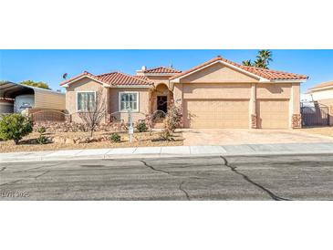 Tan two-story house with a three-car garage and desert landscaping at 1426 Radig Ct, Boulder City, NV 89005