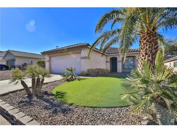 Single-story house with a landscaped front yard, two-car garage, and palm trees at 167 White Butte St, Henderson, NV 89012